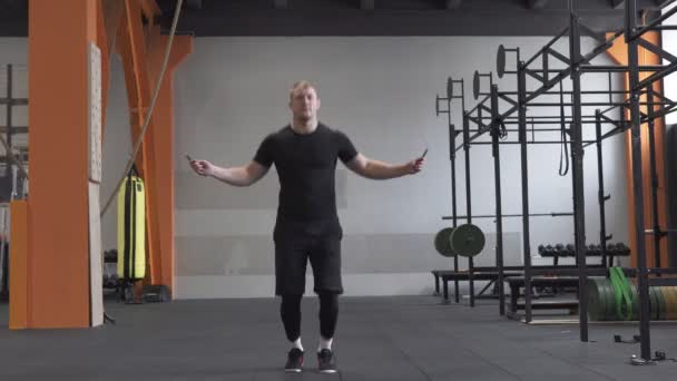 Hombre de fitness haciendo ejercicios de cuerda de saltos dobles en el gimnasio — Vídeo de stock