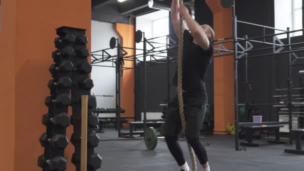 Fitness homme faisant de l'exercice d'escalade de corde dans la salle de gym — Video