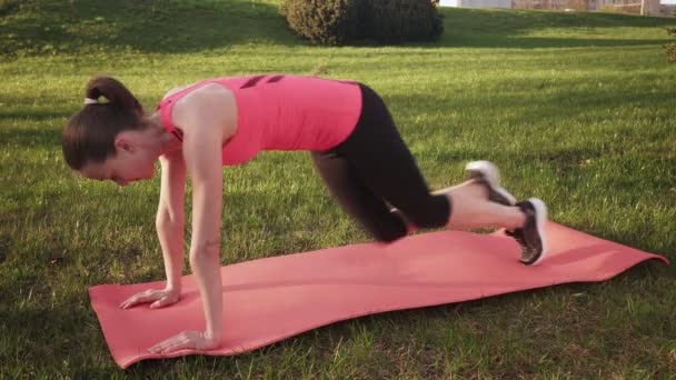 Fitness žena dělá horských horolezec cvičení na trávě venku — Stock video