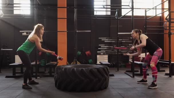 Fitness mujeres haciendo trineo martillo swing entrenamiento juntos en el gimnasio — Vídeos de Stock