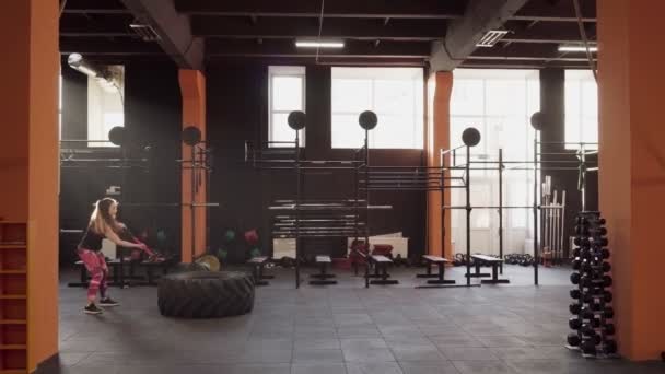 Mulher da aptidão que faz o exercício do balanço do martelo de trenó no gym na luz traseira — Vídeo de Stock