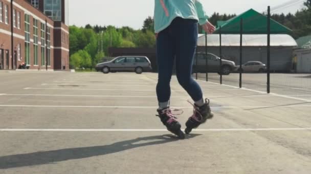 Ritten van het meisje op rolschaatsen en werveling in stad — Stockvideo