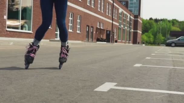 Pernas de mulheres em patins rodopiam na estrada de asfalto na cidade — Vídeo de Stock