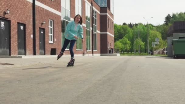 Menina feliz montando em patins de rolo na estrada de asfalto na cidade — Vídeo de Stock