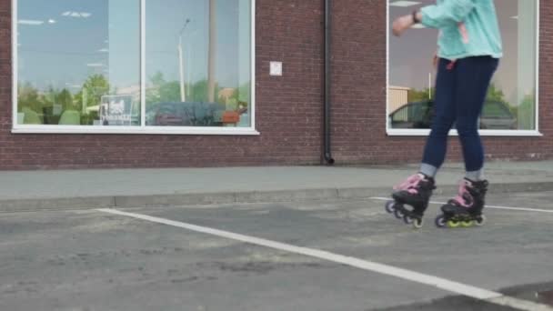 Jong meisje dwarrelen rond op rolschaatsen op stad straat — Stockvideo
