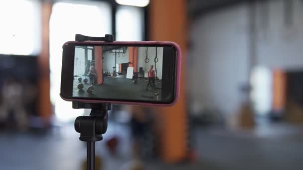 Ekranu smartfon nagrywanie wideo treningu w siłowni — Wideo stockowe