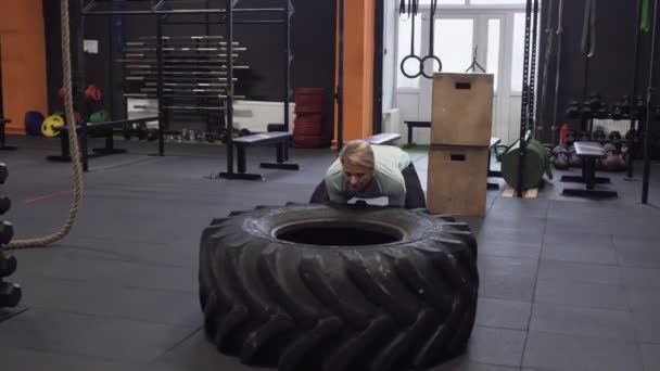 Fitness woman doing big tire flips exercise during functional training — Stock Video