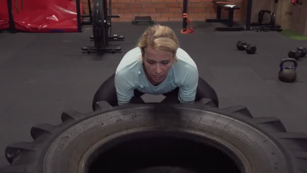 Kvinna gör stora däck flips power lifting träning på gym — Stockvideo