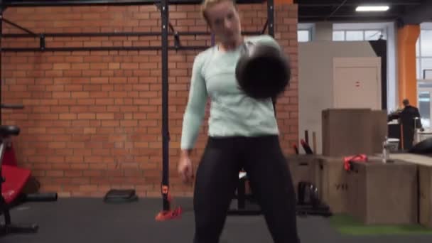 Γυμναστική γυναίκα κάνει kettlebell αρπαγή άσκηση στο γυμναστήριο — Αρχείο Βίντεο