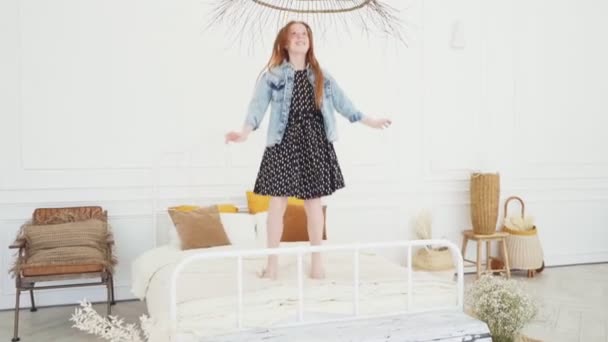 Hermosa chica adolescente saltando en la cama blanca y sonriendo — Vídeos de Stock