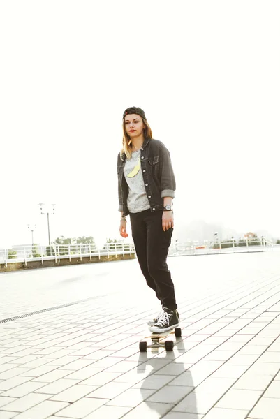 Ragazza in berretto cavalca longboard — Foto Stock