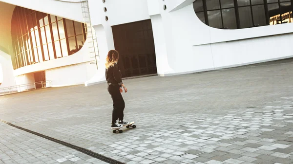 Hipster brunette woman rides longboard — Stock Photo, Image