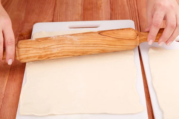 Катящееся тесто для выпечки на столе — стоковое фото