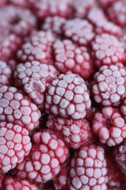 Yemek arkaplanı. Taze donmuş ahududu, dondurucu soğukta sulu bir buz parçasına dönüştü..