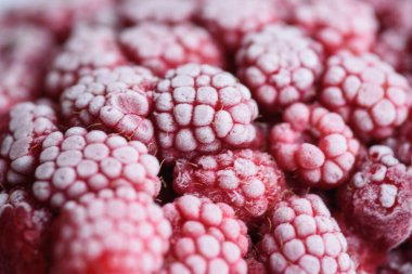 Yemek arkaplanı. Taze donmuş ahududu, dondurucu soğukta sulu bir buz parçasına dönüştü..