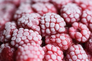 Yemek arkaplanı. Taze donmuş ahududu, dondurucu soğukta sulu bir buz parçasına dönüştü..