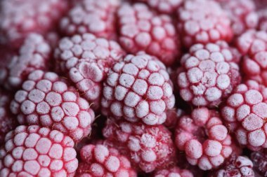 Yemek arkaplanı. Taze donmuş ahududu, dondurucu soğukta sulu bir buz parçasına dönüştü..