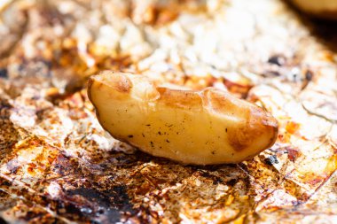 Altın kahverengiye kadar fırında folyoyla pişirilmiş patates dilimleri..