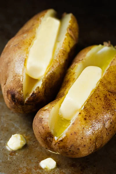 Rustic baked jacket potatoes with butter — Stock Photo, Image