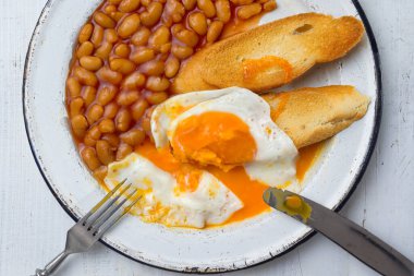 İngiliz usulü fırınlanmış fasulyeli yumurtalı tost kahvaltısına kapalı.
