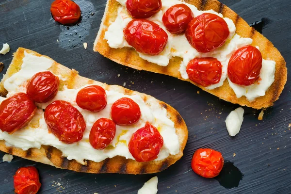 Primer Plano Bruschetta Italiana Rústica Con Tomates Cherry Caramelizados Queso —  Fotos de Stock