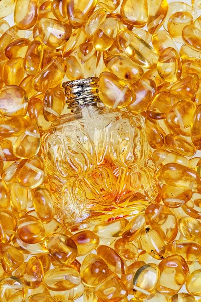 Vintage bottle and yellow amber stones. — Stock Photo, Image