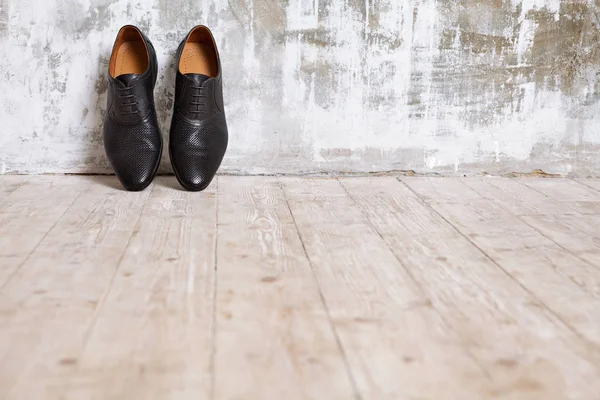 Los zapatos negros de hombre contra la pared en el interior retro . — Foto de Stock