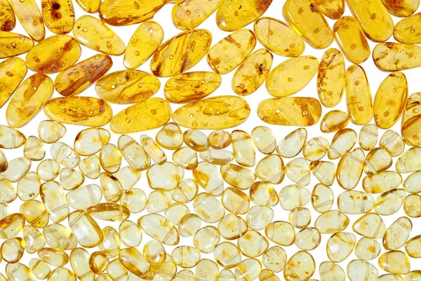 Yellow amber stones on a white background. — Stock Photo, Image