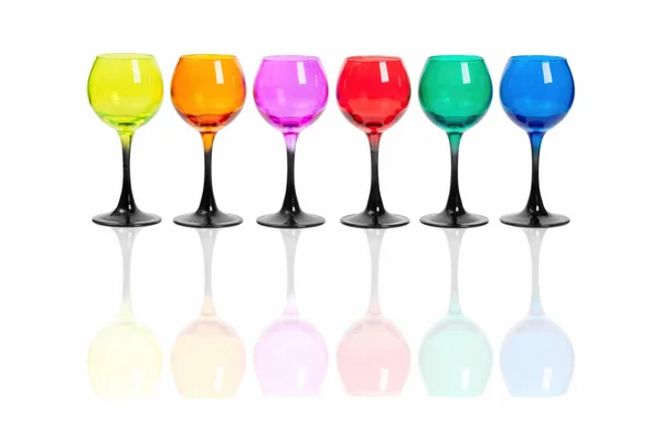 Два ряда стаканов из цветного стекла на белом фоне . — стоковое фото