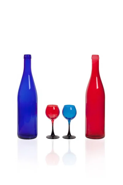 Two rows of glasses made of colored glass on a white background. Stock Photo