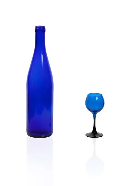 Une bouteille de verre bleu avec un verre bleu sur fond blanc . — Photo