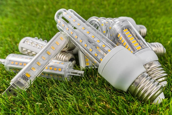 A few E27, USB and R7s LED bulbs in the grass — Stock Photo, Image