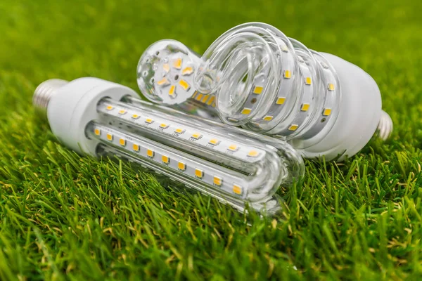 E27 LED-Lampen in ähnlicher Form wie cfl im grünen Gras Stockfoto