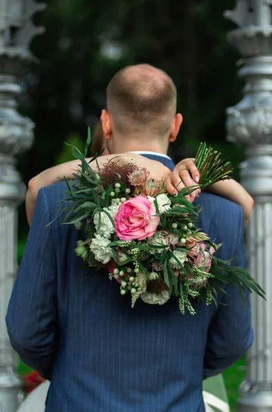 Gelinin Kolları Damadın Boynuna Dolanmış Renkli Düğün Buketini Yakın Tutuyor — Stok fotoğraf