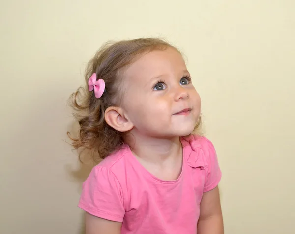 Portrait of the amusing two-year-old girl on a light background — Stock Photo, Image