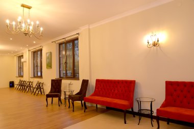 Hall interior with upholstered furniture and chairs along a wall clipart