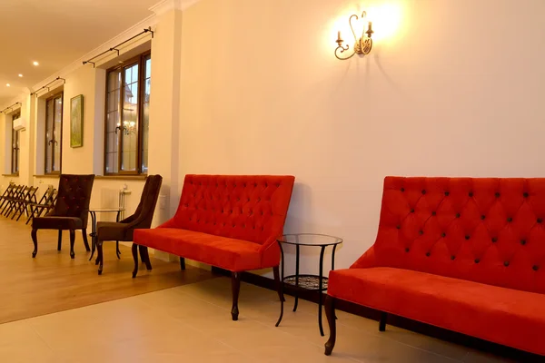Los muebles tapizados cuestan a lo largo de una pared en el pasillo. Interior — Foto de Stock