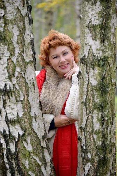Portrét veselé ženy průměr let mezi břízy v lese — Stock fotografie
