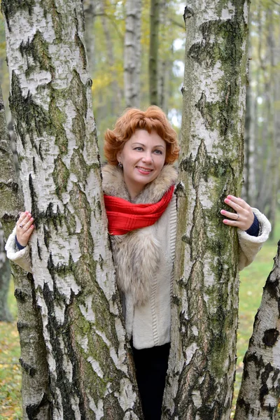 Portrait de la joyeuse femme des années moyennes parmi les bouleaux dans le bois — Photo