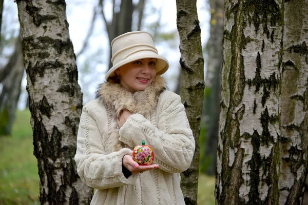 La femme dans un chapeau montre pomme décorative sur une paume — Photo