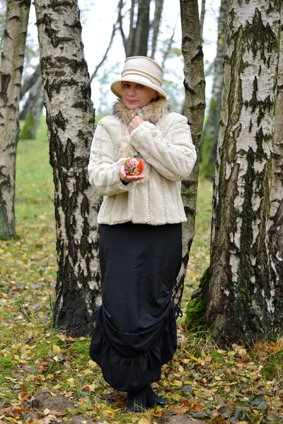 Žena v průměru let v klobouku ukazuje dekorativní apple na kamaráda — Stock fotografie
