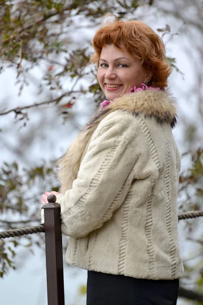 Portrait de la femme heureuse des années moyennes dans un manteau de fourrure court léger — Photo