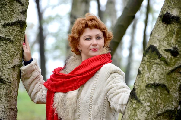 Portrait de la fière femme avec une écharpe rouge parmi les bouleaux — Photo