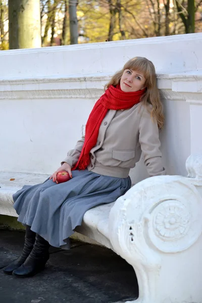 The young woman has a rest on a bench in the autumn park — Stock Photo, Image