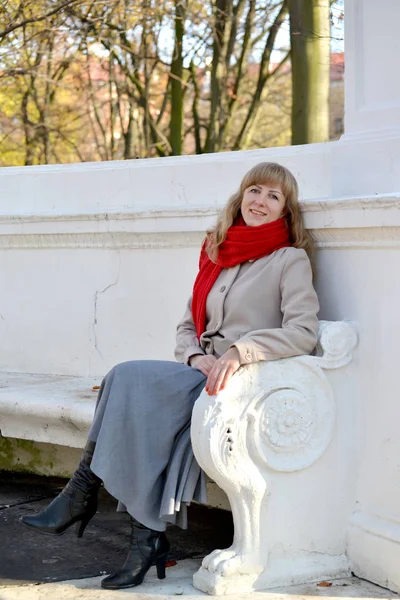 La jeune femme à la pomme rouge à la main s'assoit sur un banc dans le parc — Photo