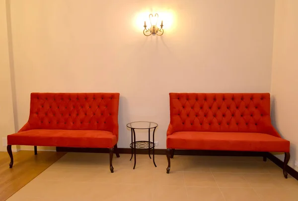 Two red sofas stand at a wall in a drawing room — Stock Photo, Image