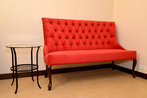 De rode sofa en metalen koffietafel staan op een muur in een salon — Stockfoto