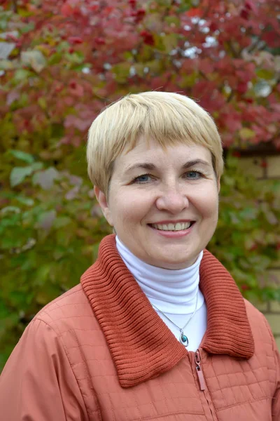 Portrait of the woman of average years against the background of an autumn tree — Stock Photo, Image