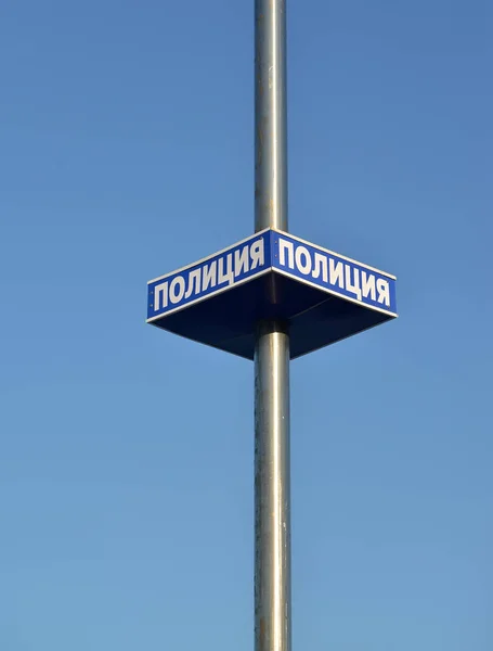 Табличка с надписью "полиция" закреплена на металлической колонне. Русский текст "Полиция " — стоковое фото
