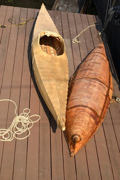 The boat from birch bark and a kayak lie on a board scaffold — Stock Photo, Image